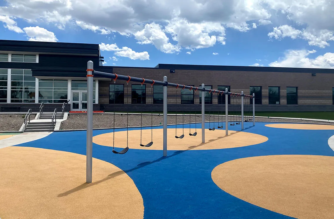 Multiple playground ground swings over rubber surfacing at Del Norte Elementary school in Del Norte, CO